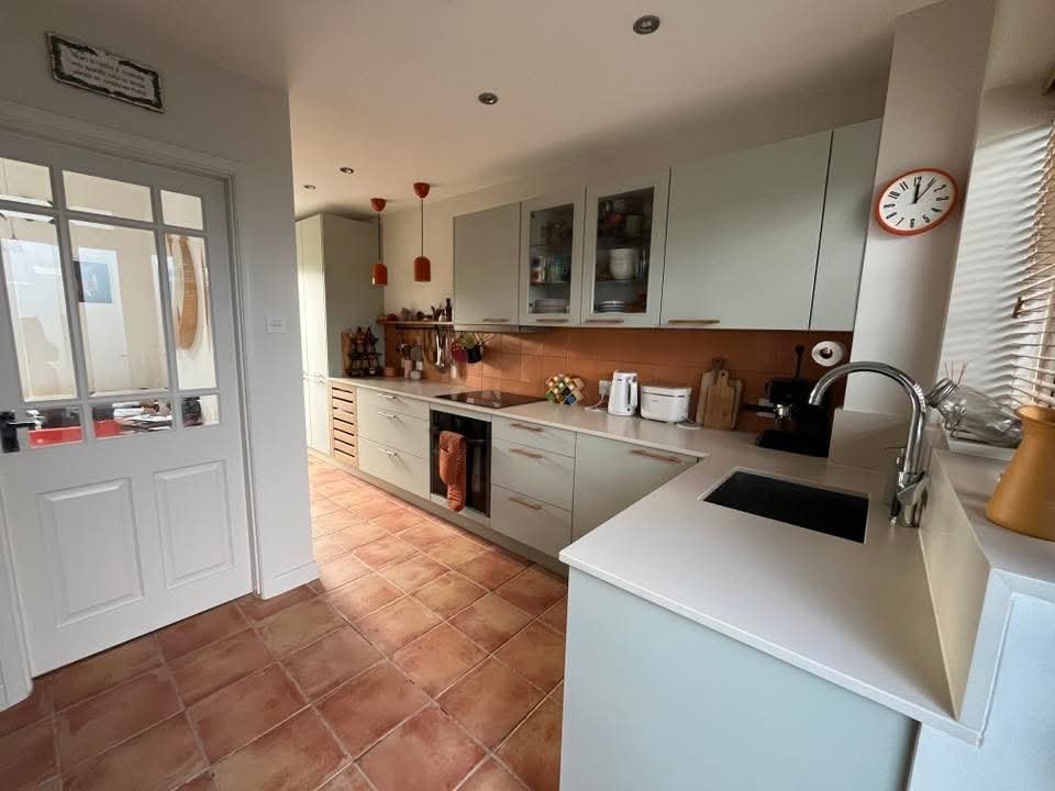Modern kitchen after renovation with upgraded cabinets, lighting, and finishes